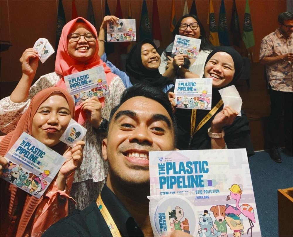 Indonesian students and educators taking a selfie with the plastic pipeline brochures and sticker