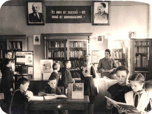 Children reading in the Central City Children's Library of Samara under the portraits of Stalin and Lenin in 1938
