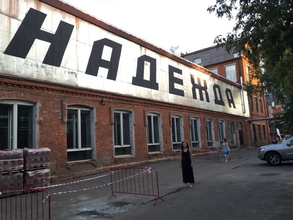 Kathryn David stands in front of a large sign that reads "hope" in Russian