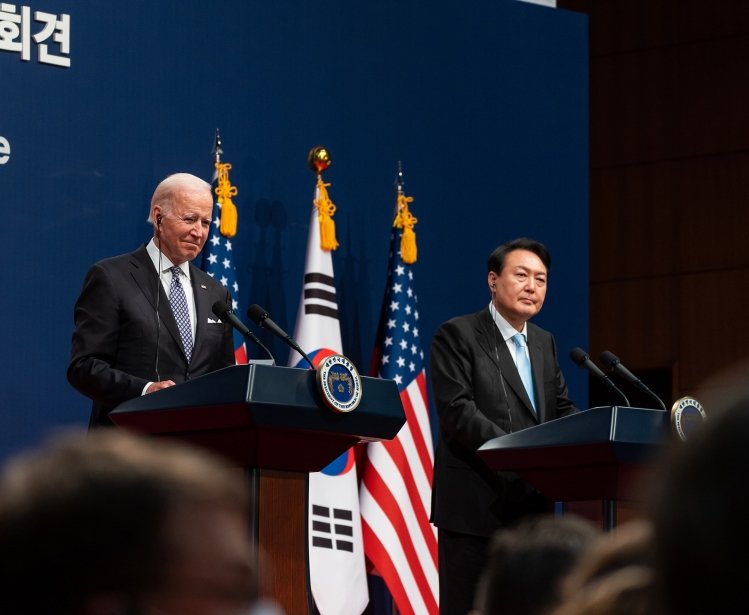 President Biden and President Yoon standing at two adjacent podiums with U.S. and ROK flags in the background.