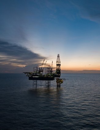 A picture of an offshore oil rig at sunset.