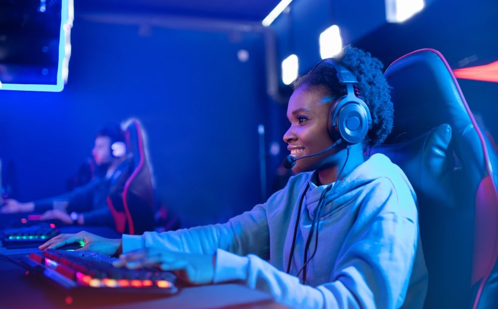 Portrait Streamer African young woman professional gamer playing online games computer, neon color.