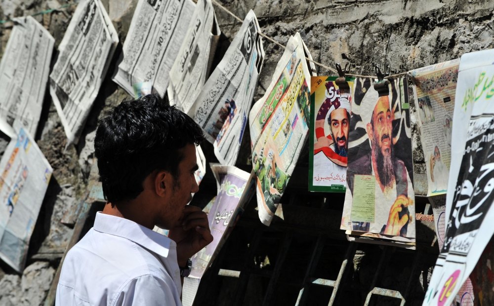 Man looking at Newspapers with Bin Laden's Photo