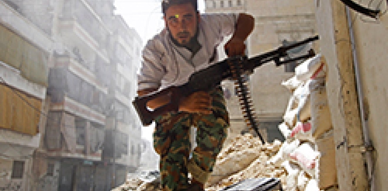 A Free Syrian Army fighter takes cover during clashes with Syrian Army in the Salaheddine neighbourhood of central Aleppo August 7, 2012.