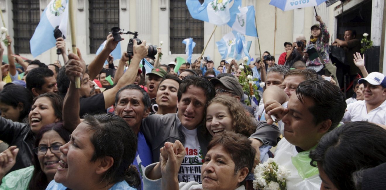 People react outside of the Guatemalan Congress building after the congress voted to strip President Otto Perez of immunity, in Guatemala City, September 1, 2015. 