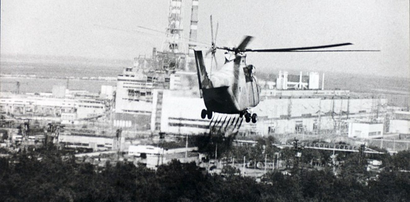 Image: A helicopter sprays a decontamination liquid nearby the Chernobyl reactor in 1986. Source: IAEA Imagebank #02790036, via Wikimedia Commons, CC BY-SA 2.0.