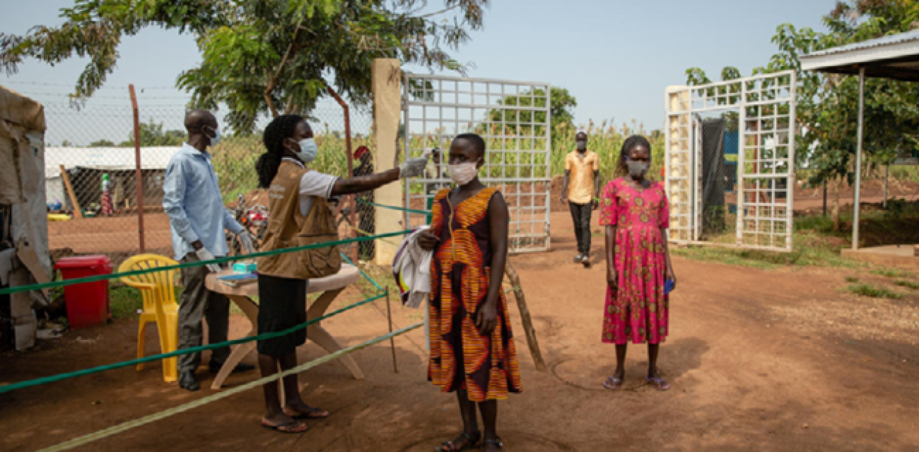 A South Sudanese refugee has her temperature checked before entering a health centre in Uganda’s Bidibidi refugee settlement. © UNHCR/Esther Ruth Mbabazi