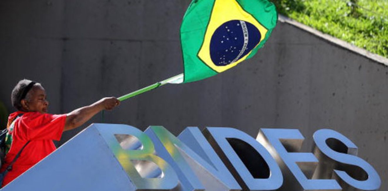 An elderly woman waves a Brazilian flag