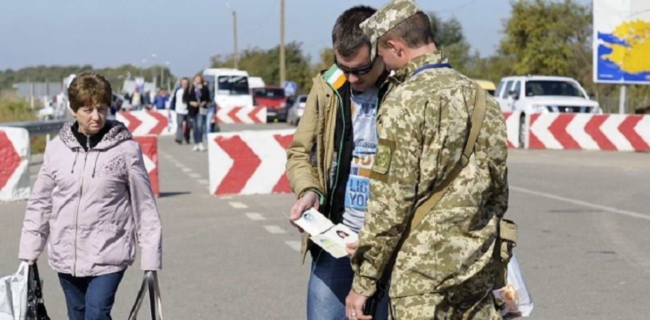 Border guard checking traveler’s passport at the border crossing point Kalanchak. September 20, 2017. Khersonskaya oblast, Ukraine. Source: Shutterstock.