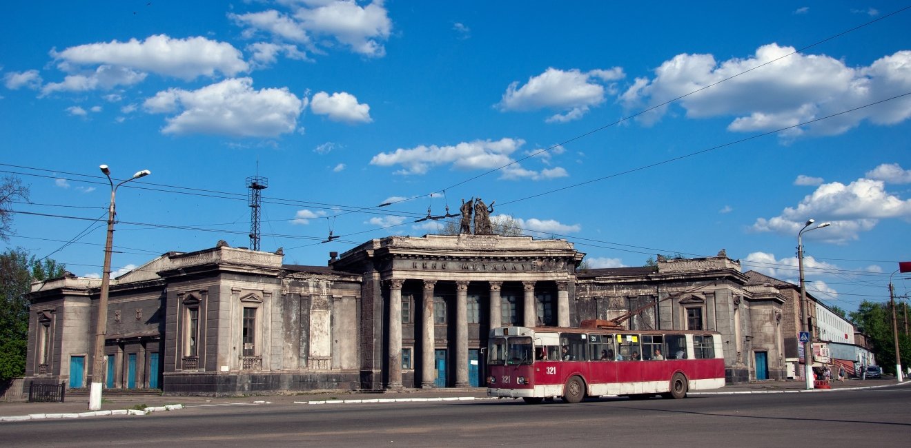 Old soviet red trolleybus with abandoned building of cinema "Metallurg". Soviet stalin architecture. Alchevsk, Luhansk region, Ukraine. Source: Shutterstock