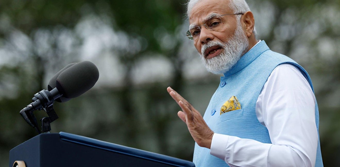 A photo of Narendra Modi speaking at a podium.