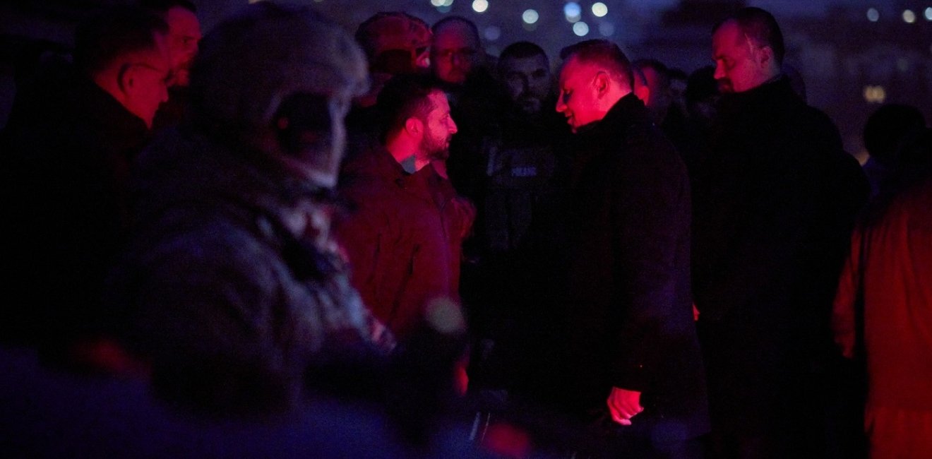 Group of men standing in a cemetery at night