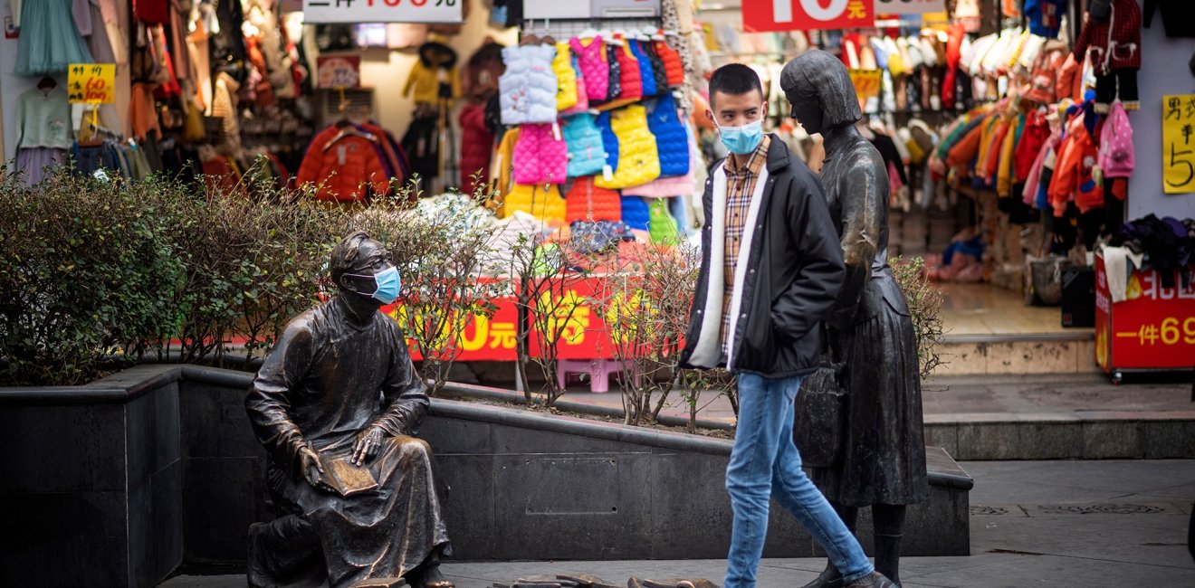 A person and a statue both wear masks on the street to prevent infection from coronovirus during the Chinese New Year in Chengdu, China.