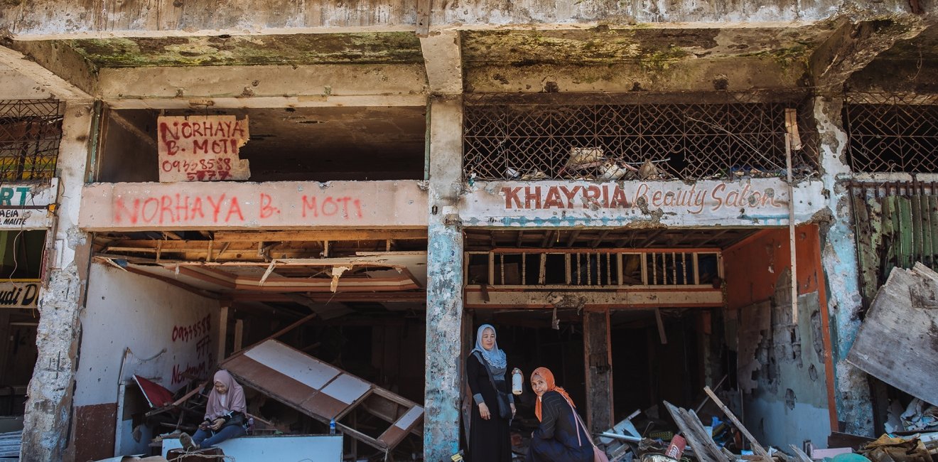 Two women in the ruins of a building in Marawi City, Philippines.