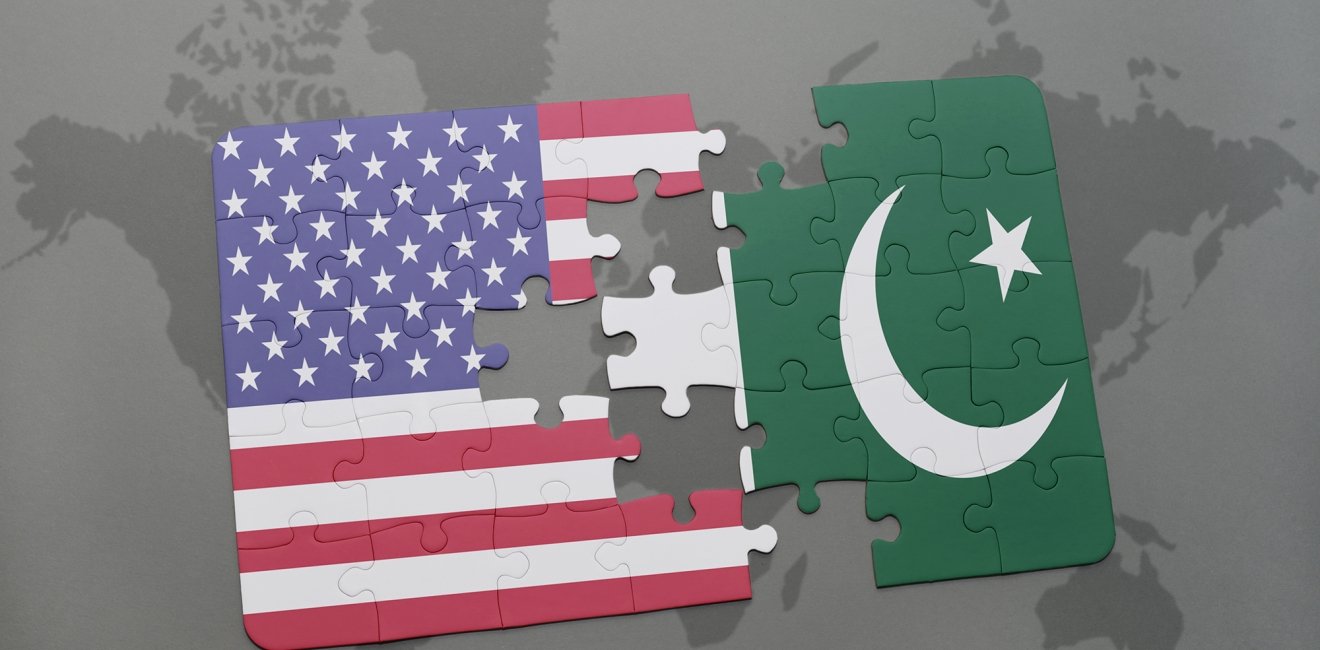 A puzzle that is split in the middle, one side showing the U.S. flag and the other the Pakistan flag