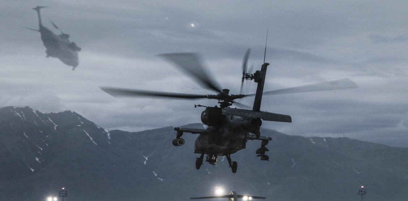 An image of an AH-64 helicopter in Aghanistan with another image superimposed on top showing CH-53 helicopters in Vietnam