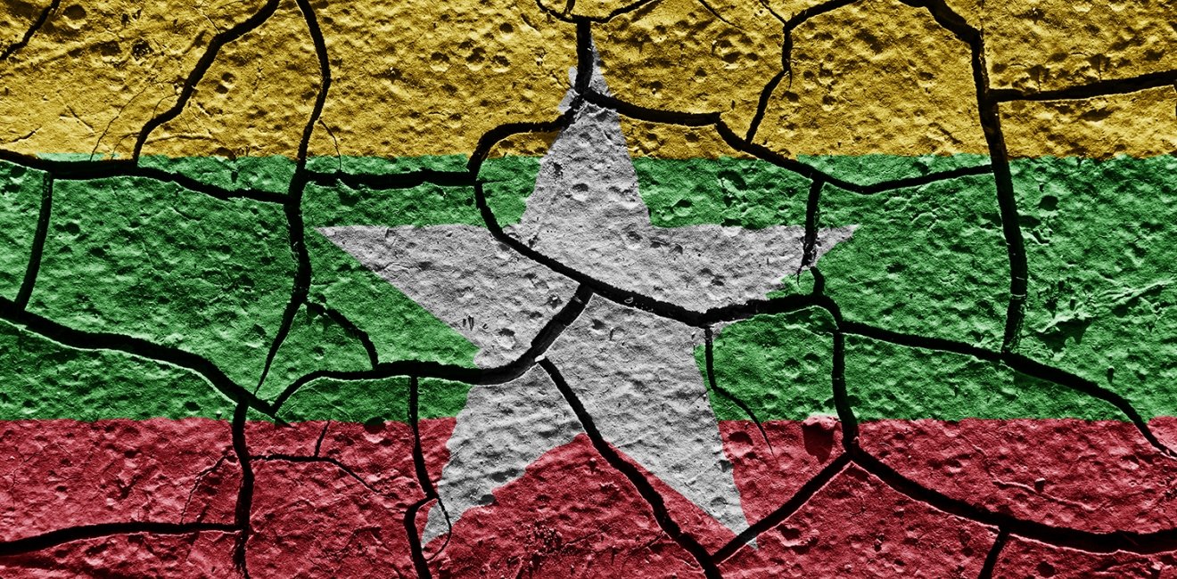 The flag of Myanmar painted on cracked pavement