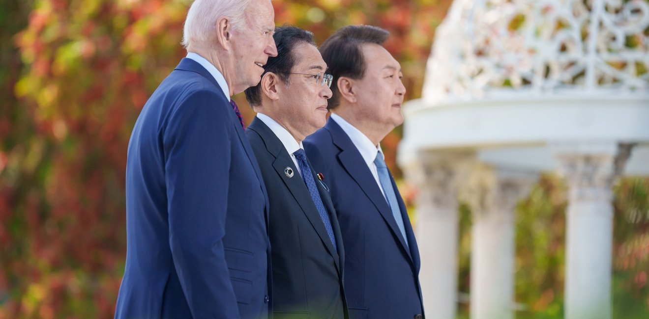 President Biden, Prime Minister Kishida, and President Yoon standing together outside looking off camera.