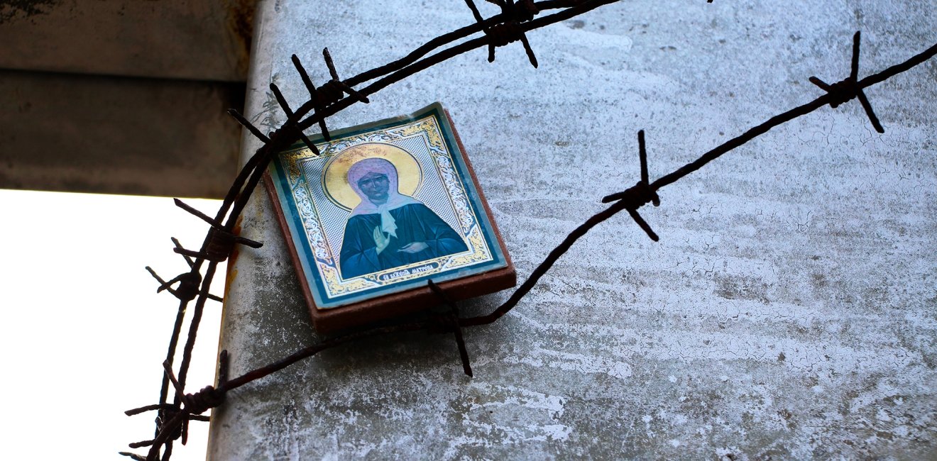 The icon of the Holy Mother is fixed under the barbed wire on the memorial cross to the victims of the Gulag. Stalinist repression. 