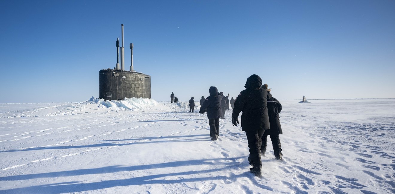 Chief of Naval Operations Adm. Lisa Franchetti walks with other distinguished visitor towards the Virginia-class fast-attack submarine USS Indiana (SSN 789) before embarking Indiana during Operation Ice Camp (ICE CAMP) 2024.