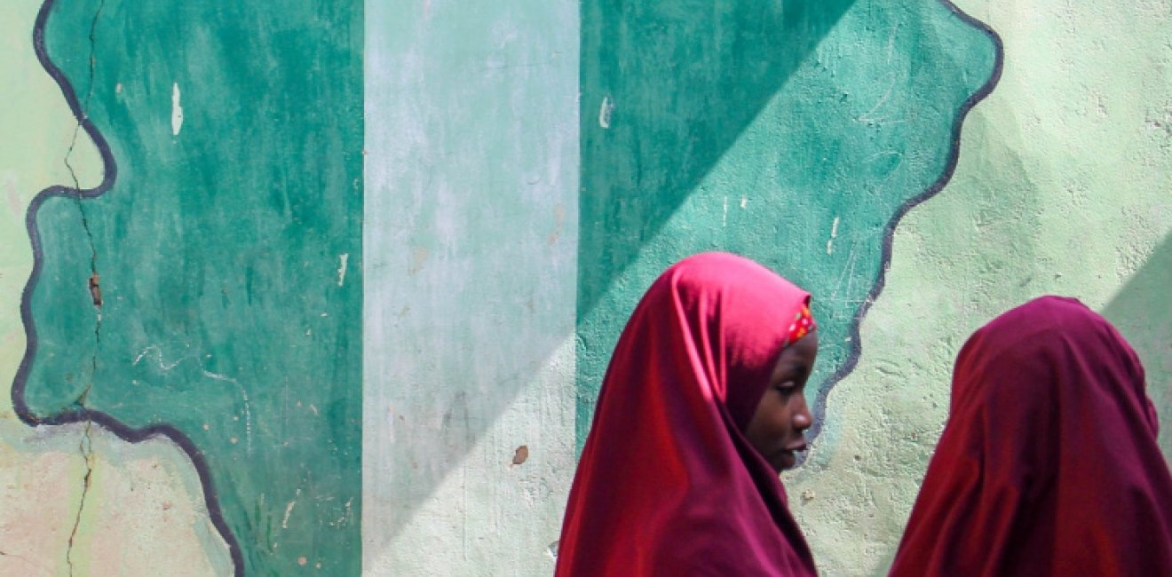 Girl students pass a classroom with the map and flag of Nigeria painted on it, at Success Private School, one of the first schools attacked by Boko Haram in '09.