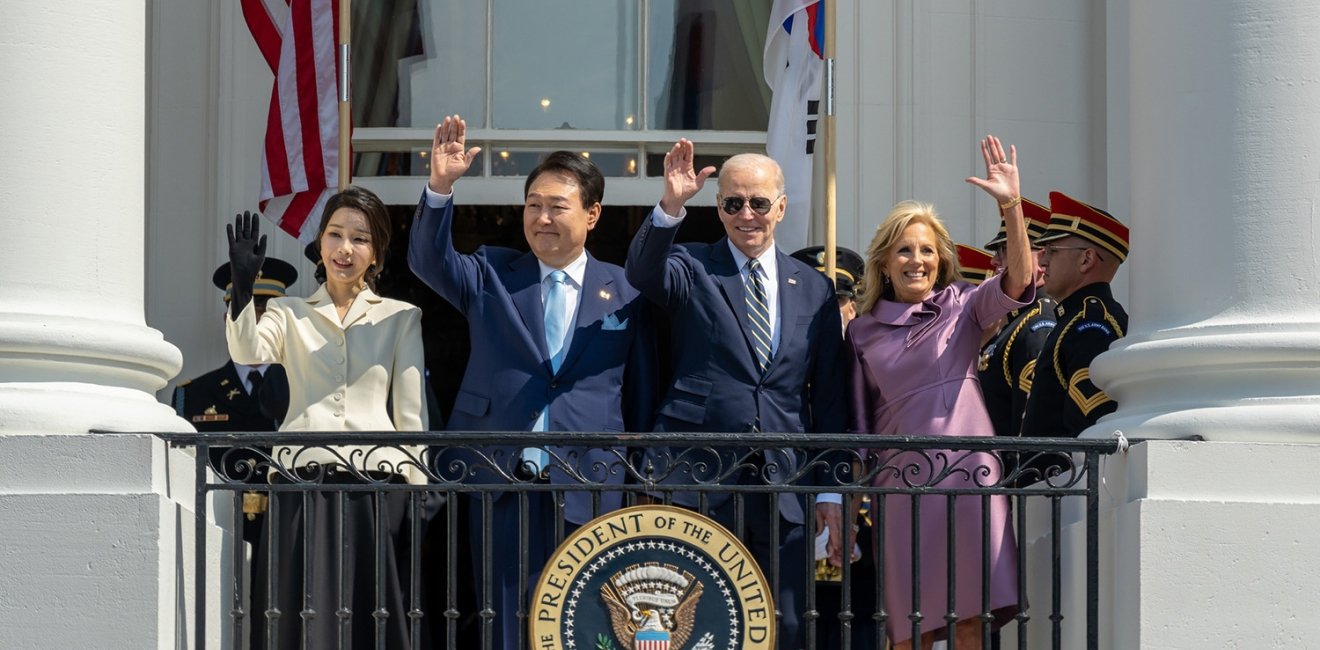 Presidents Yoon and Biden with their wives waving from the balcony at the White House