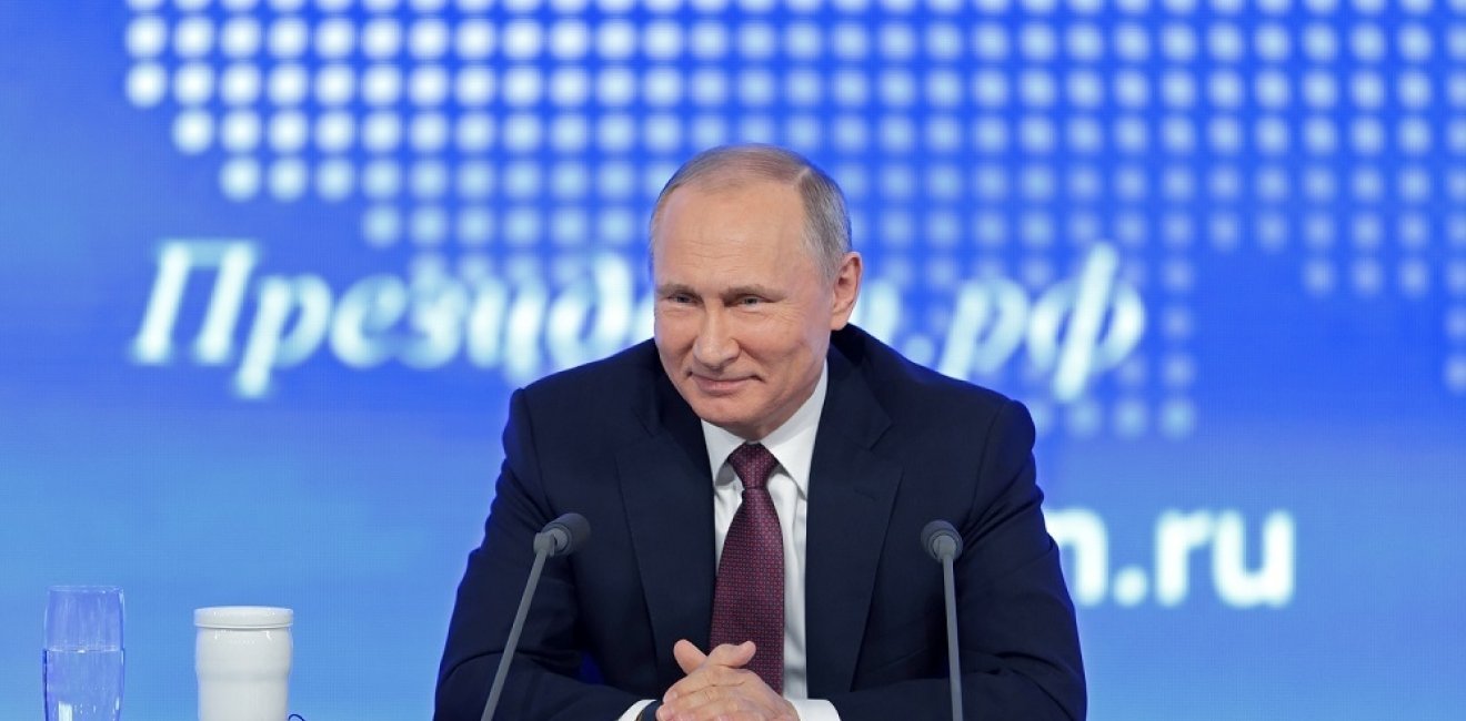 Image of Vladimir Putin smiling while taking questions