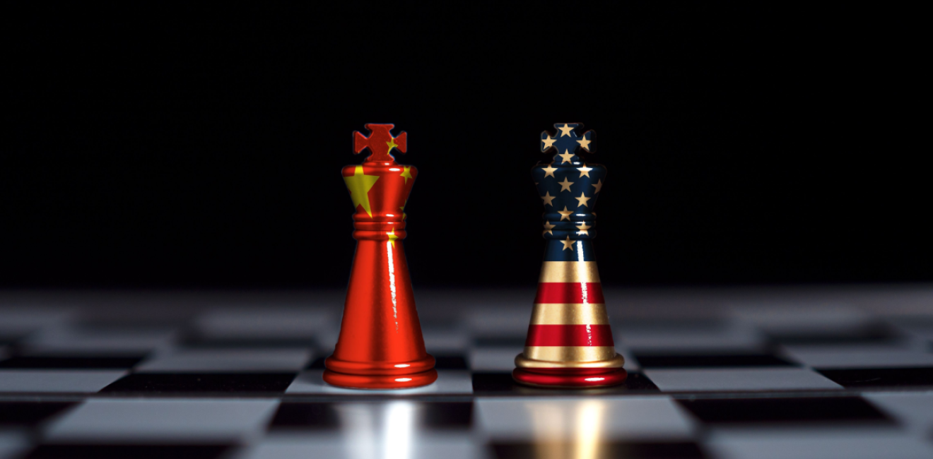 Chess pieces stand text to each other wrapped in the US and Chinese flags