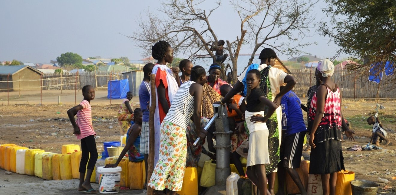 Juba, South Sudan, February 2017. People with yellow jerrycans waiting for water at a borehole site. Salesian camp for internally displaced persons (IDPs). Captured during civil war.