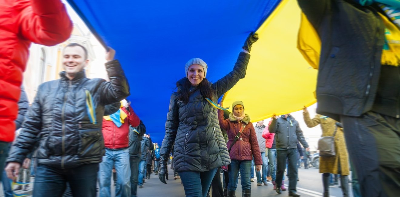 Street protestors hold a giant Ukrainian flag