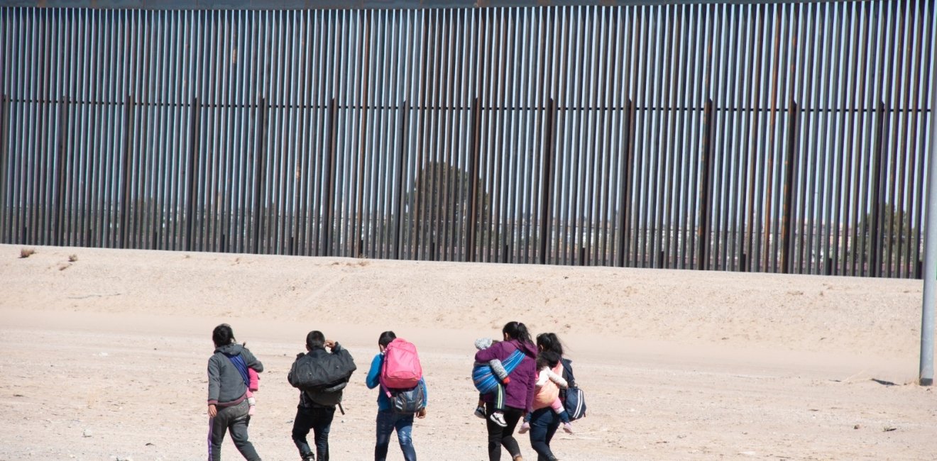 A group of migrants walks near the U.S. border.