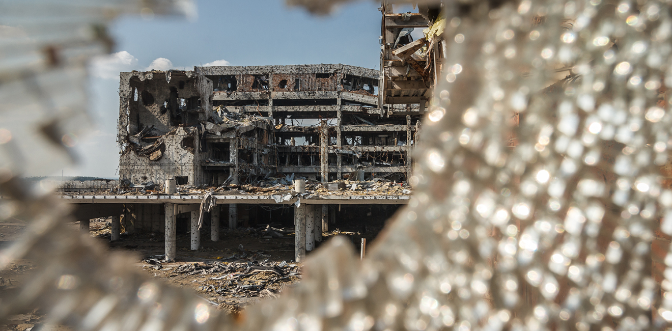 Wide angle view of Donetsk airport ruins through broken glass after massive artillery shelling.