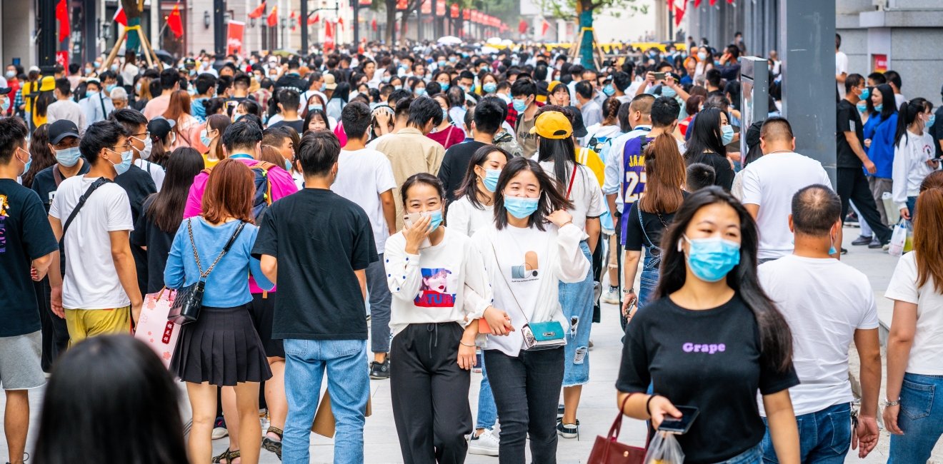 People walking along a street wearing masks in China 