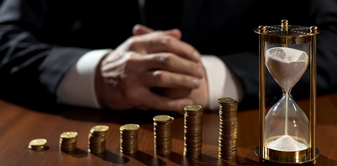 Pile of coins and an hourglass