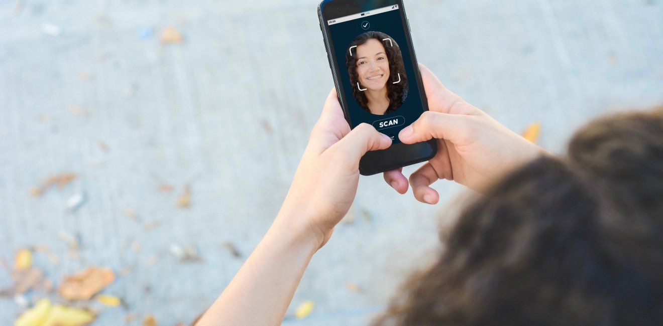 Woman unlocking smartphone with facial recognition technology. Biometric verification and face recognition concept.