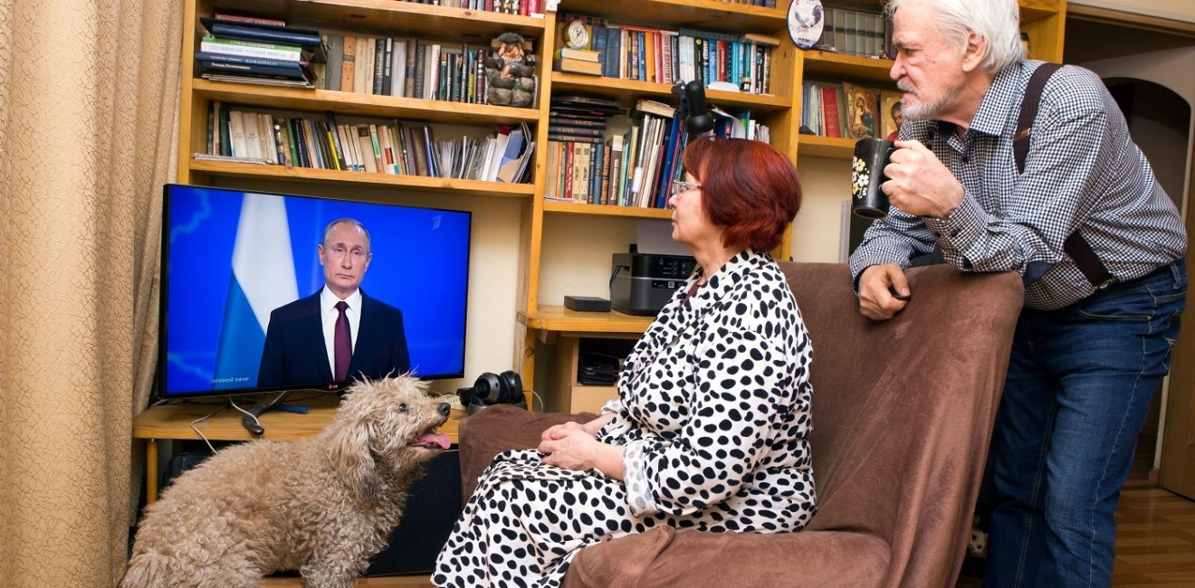 Russian pensioners watch Vladimir Putin's presidential address on television