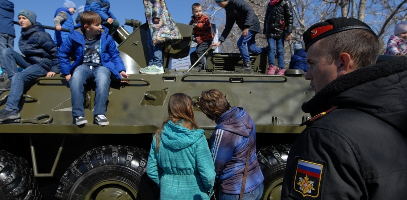 children play on a Russian armored car on the fifth anniversary of the annexation of Crimea