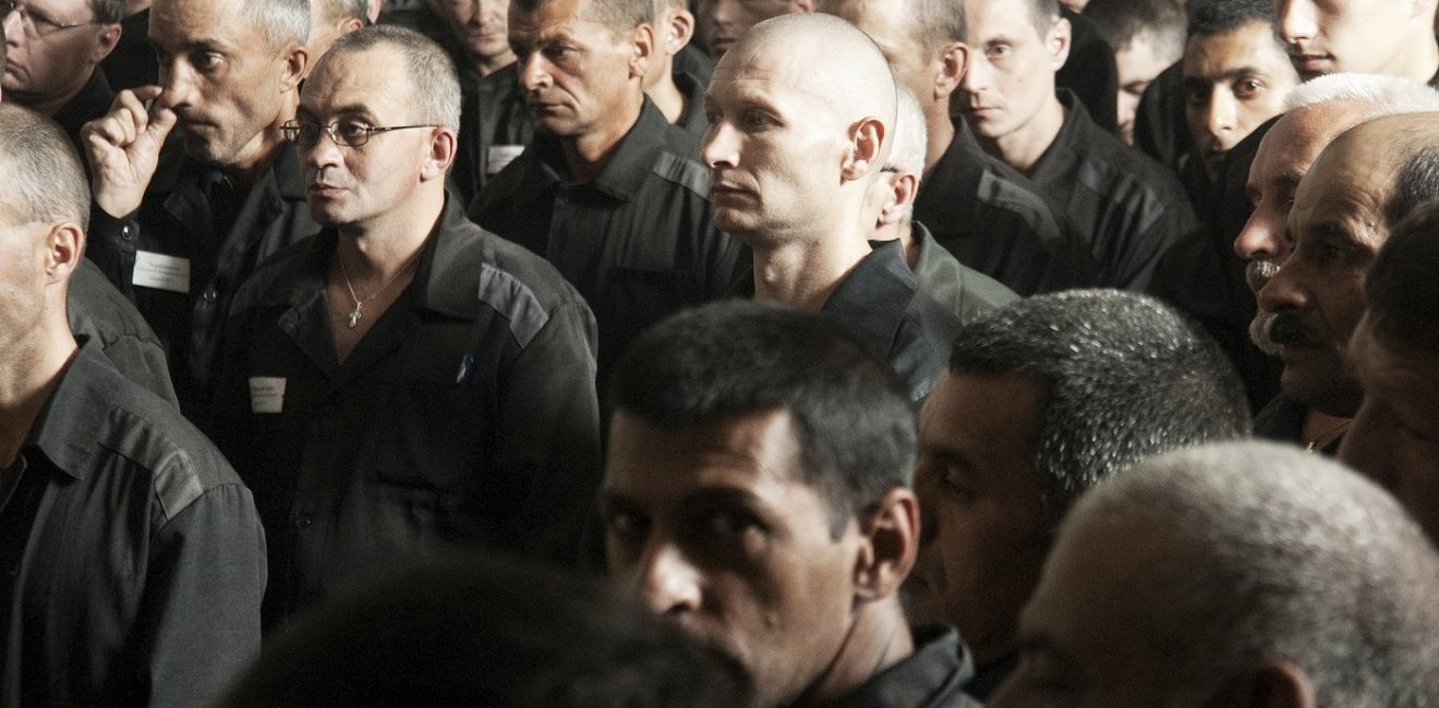 Large group of men in prisoner clothing 