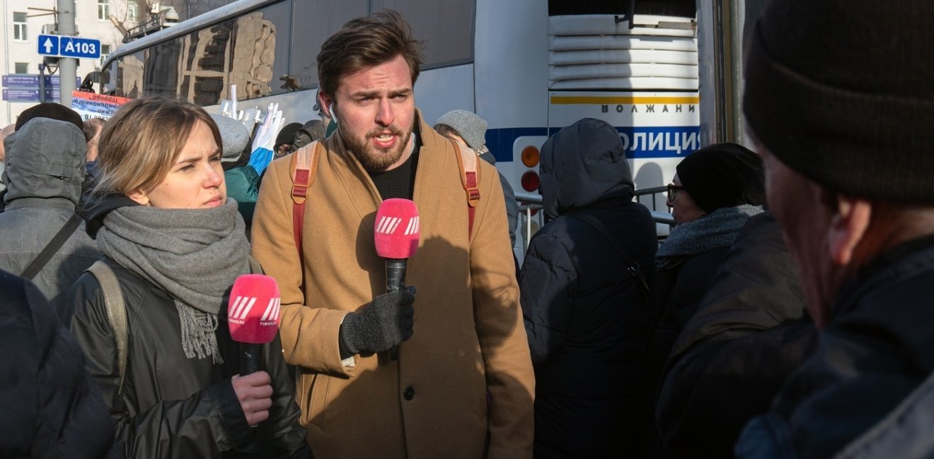 Image of two reporters with microphones 