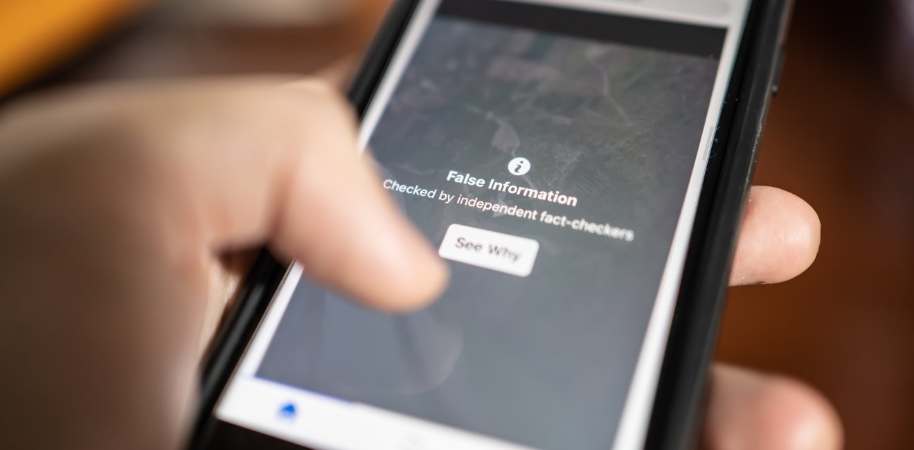 A phone displays a warning about false information.