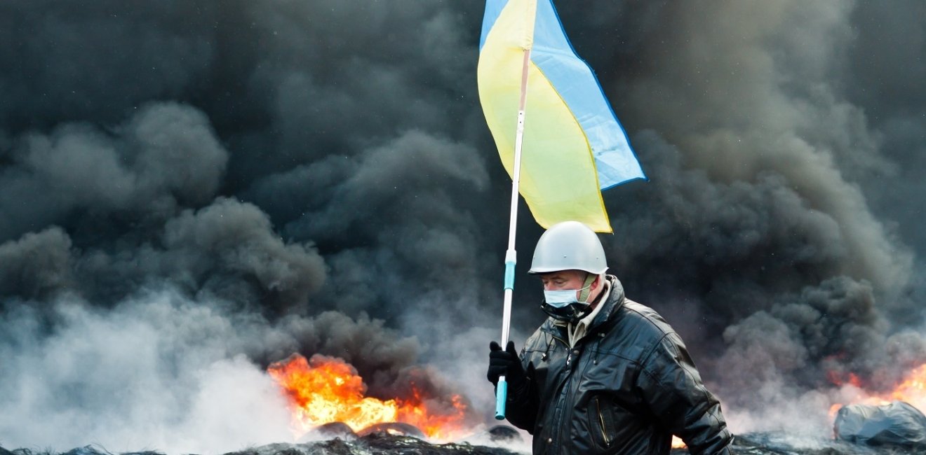 Unknown demonstrator carrying a Ukrainian flag at the Independence square in Kyiv during Euromaidan