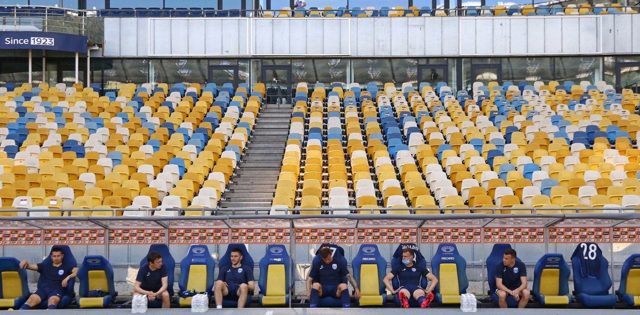 Desna Chernihiv players sit on a bench keeping a safe quarantine distance during the Ukrainian Premiere League game against Shakhtar at NSC Olympiyskyi stadium in Kyiv