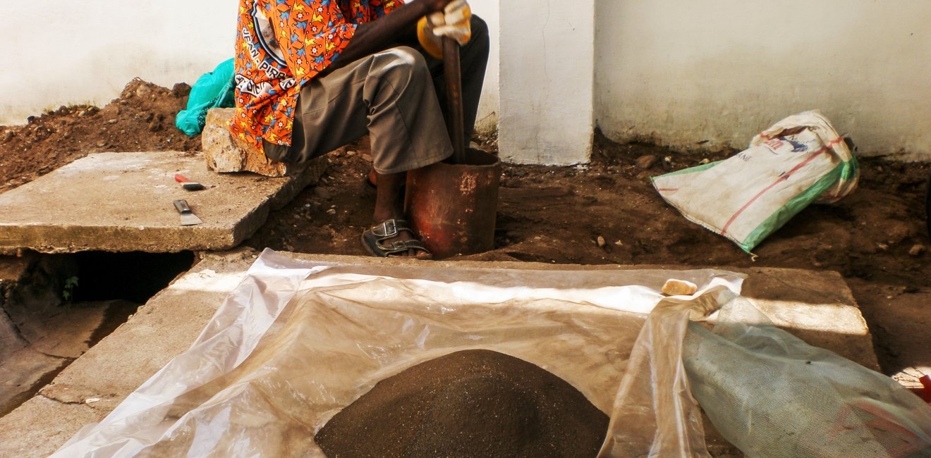 A Congolese man grinding coltan ore.