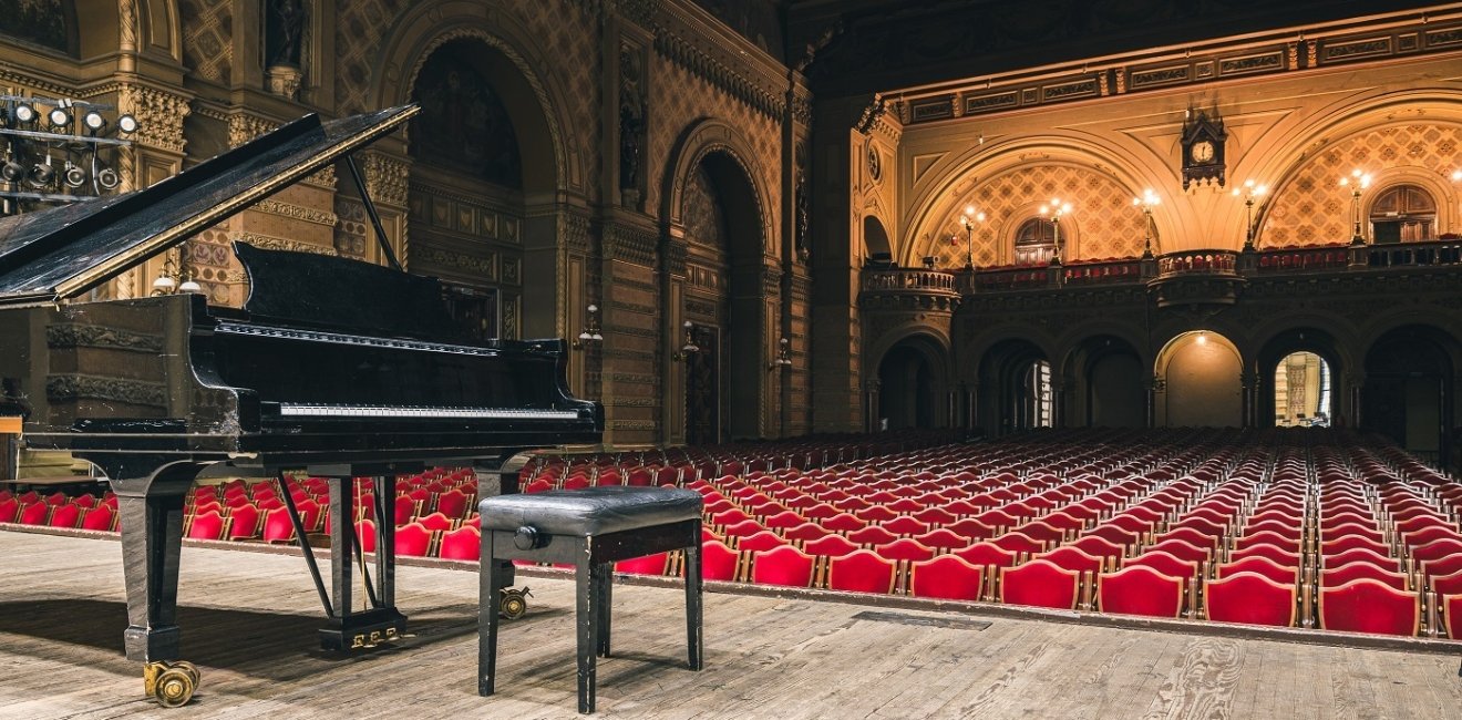 Image of piano on concert hall stage 