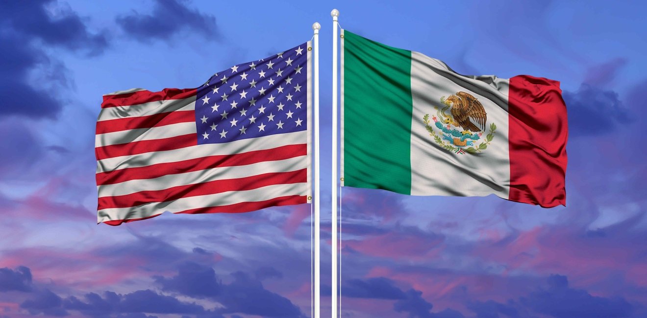 U.S. and Mexican flags at sunset