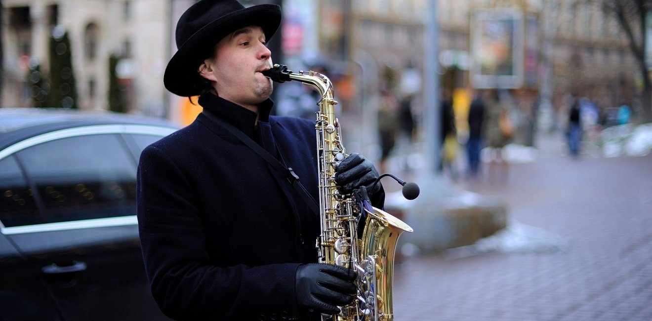 street musician, playing saxophone on a street. March 5, 2019. Kiev, Ukraine