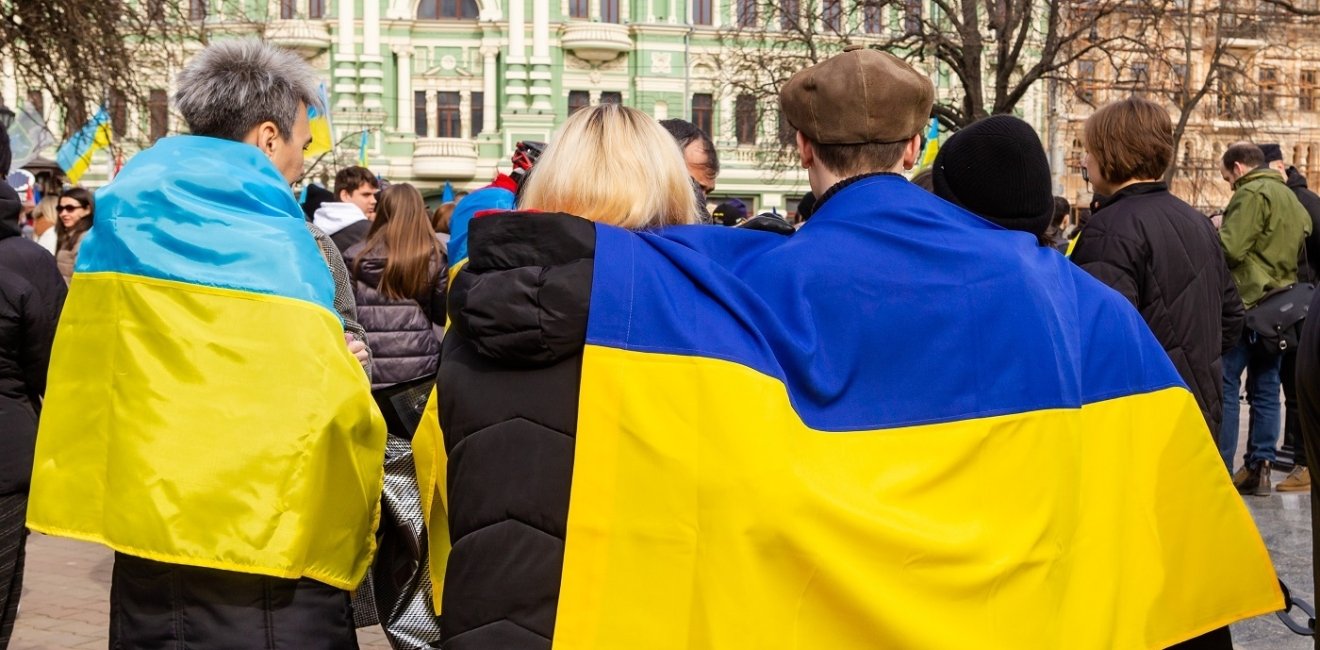 Ukrainian flag draped over peoples' backs