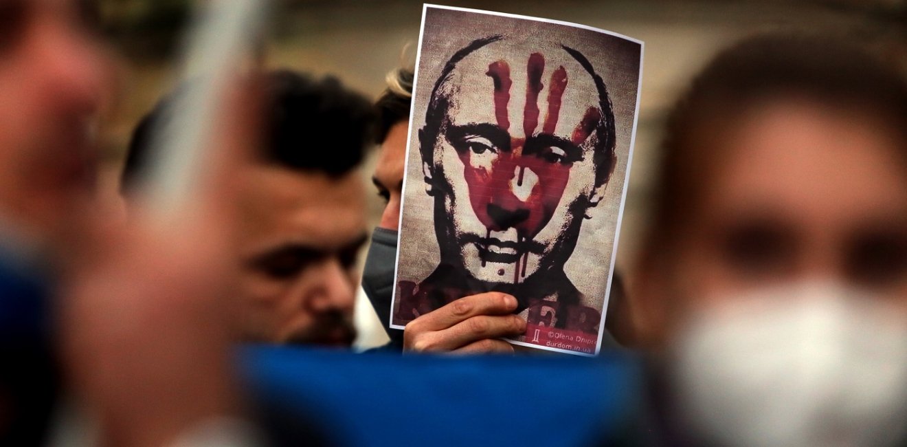 Putin's bloody face on a poster is shown during Ukrainian protesters with candles gather in Piazza del Campidoglio in Rome, against the war operations of Russia in Ukraine