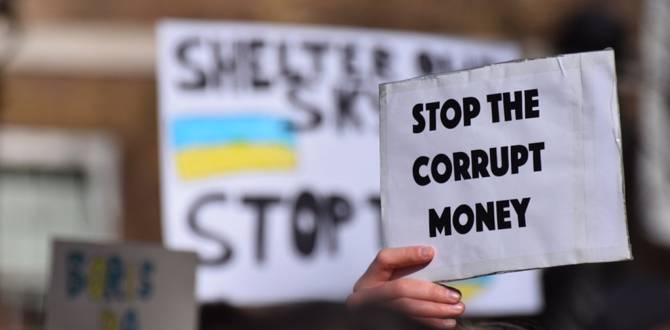 Person holding sign that reads "stop the corrupt money"