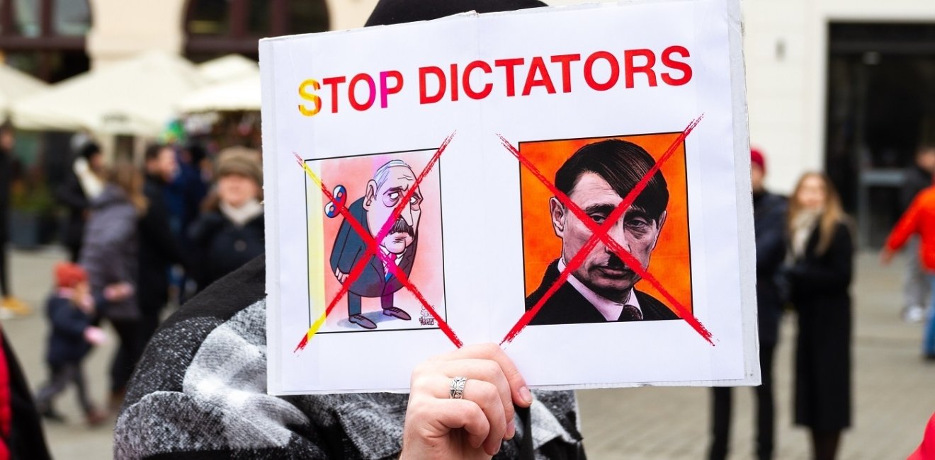 Protest poster with phrase "STOP DICTATORS" and satirical images of Putin and Lukashenko